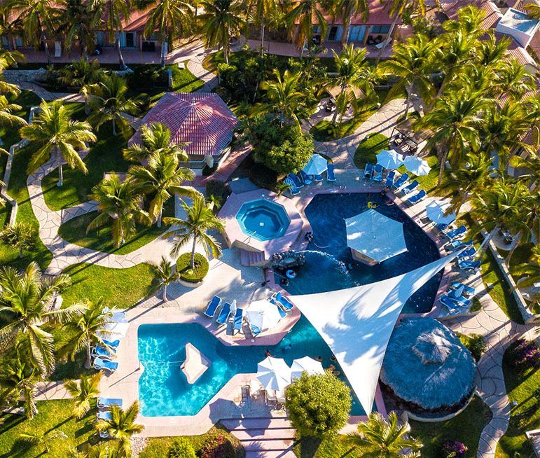 Uma vista aérea de uma grande piscina cercada por palmeiras