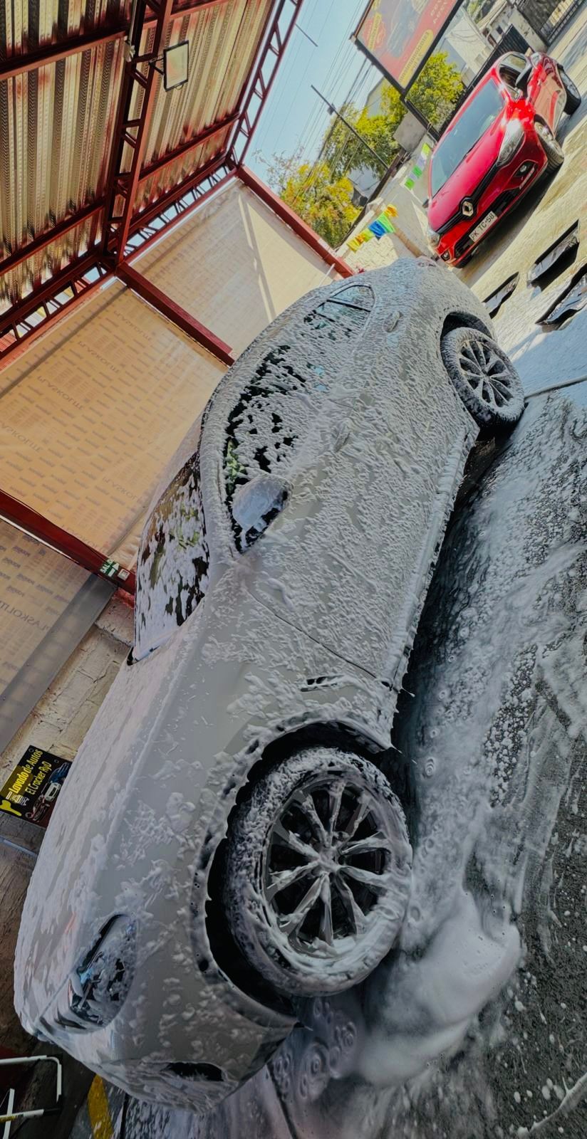 Un coche está cubierto de espuma en un lavadero de coches.