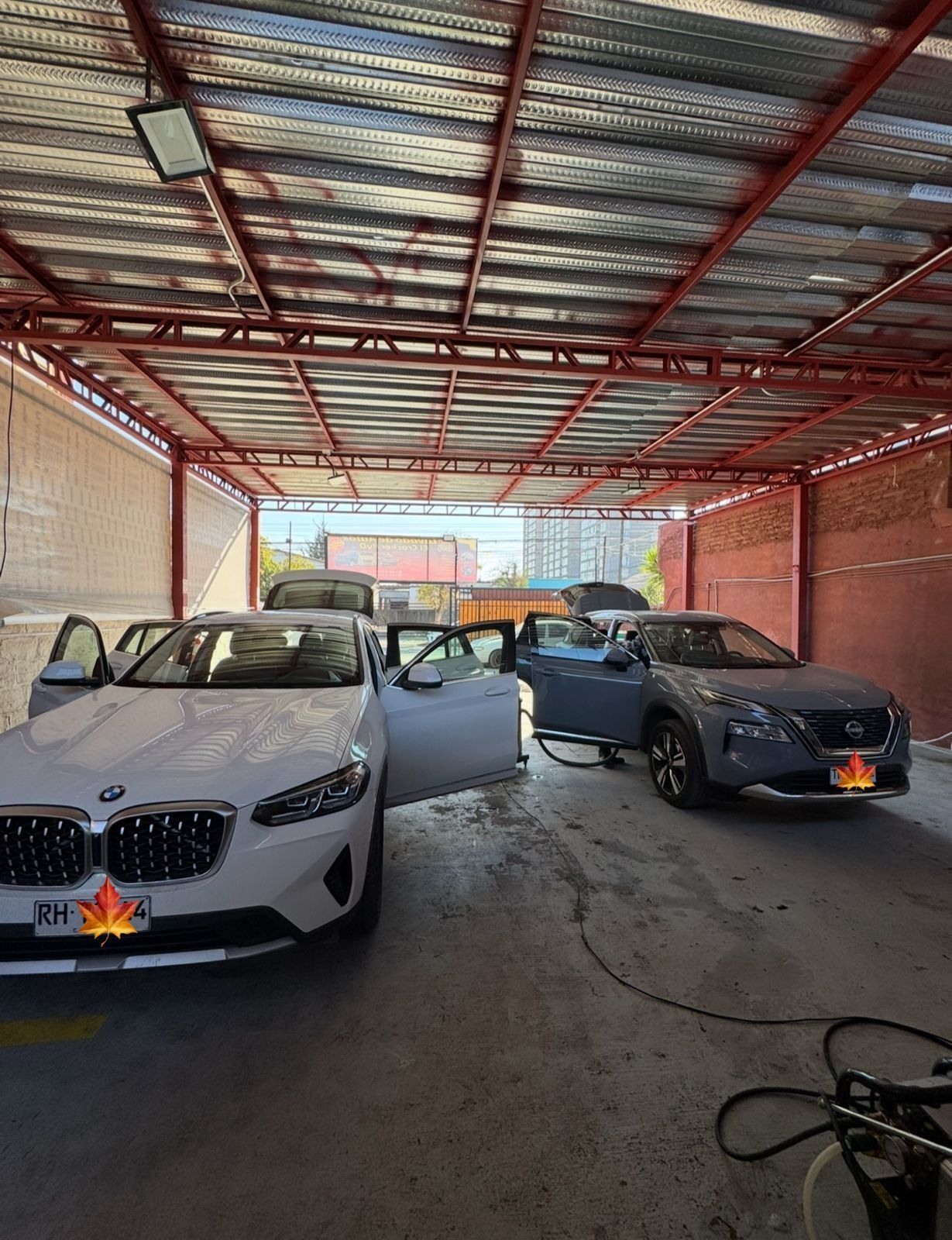 Dos coches están aparcados bajo techo en un garaje.