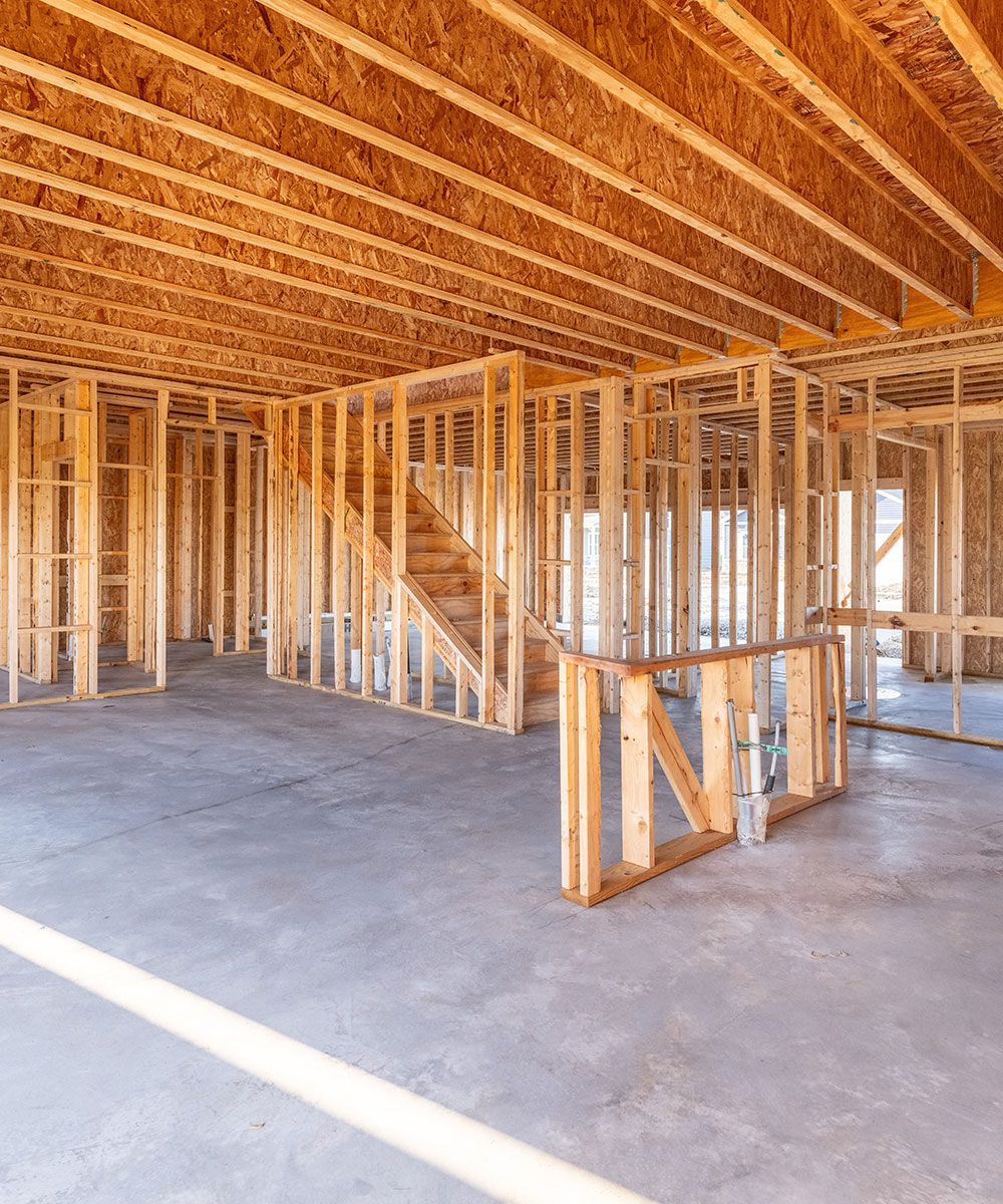 A house is being built with wooden beams and a staircase.