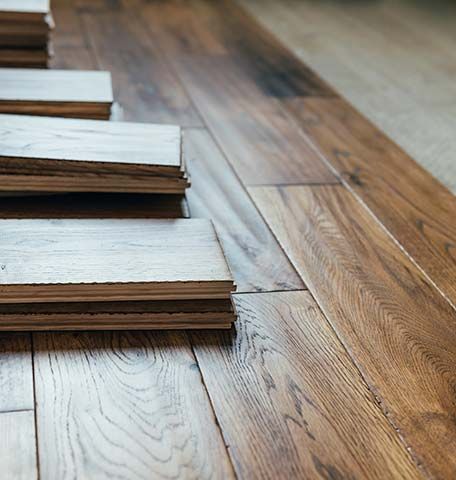 A stack of wooden flooring sitting on top of each other on a wooden floor.