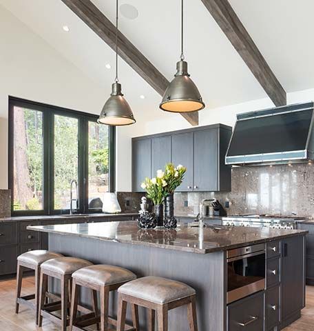 There is a large island in the middle of the kitchen with stools.