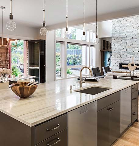 A kitchen with a large island , sink , and cabinets.