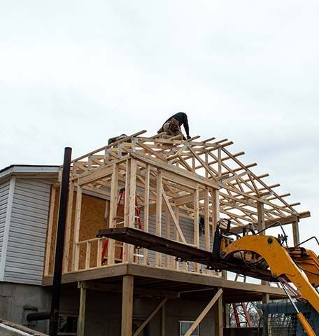 A man is working on the roof of a house under construction.