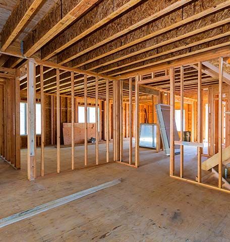 The inside of a house under construction with wooden beams.