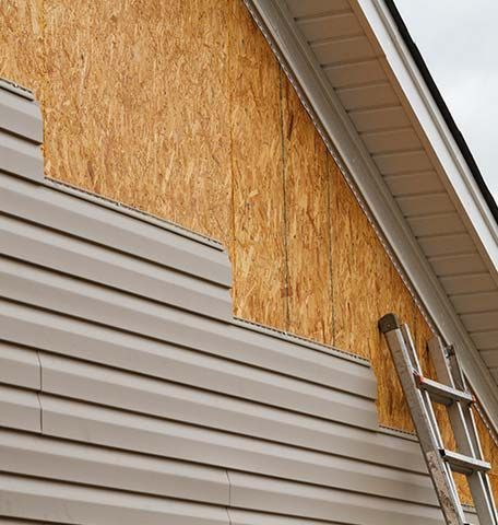 A ladder is sitting on the side of a house.