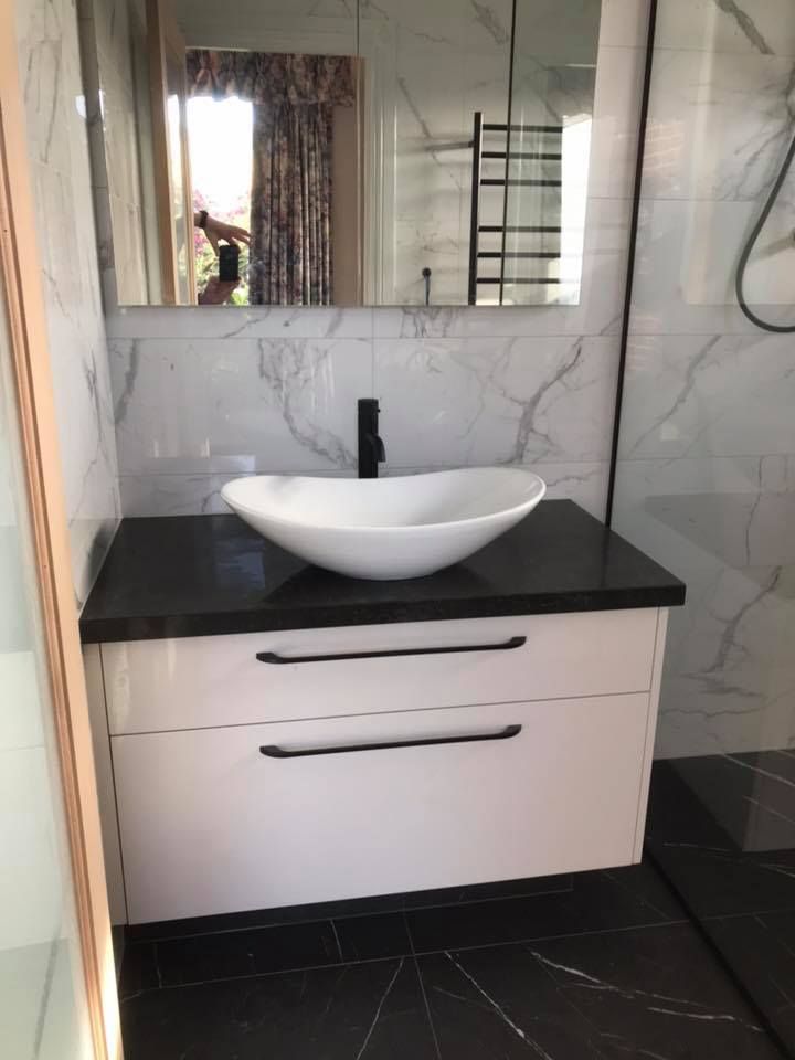 A bathroom with a sink and a mirror on the wall.