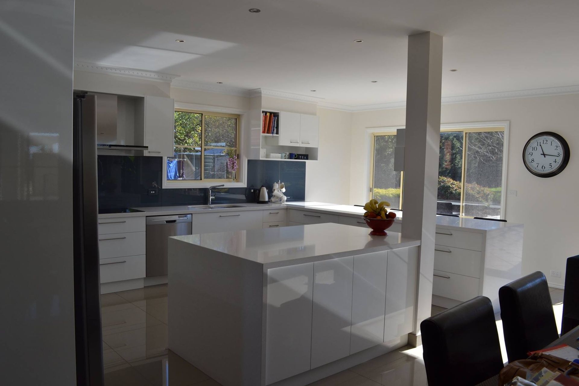 A kitchen with a large island and a clock on the wall