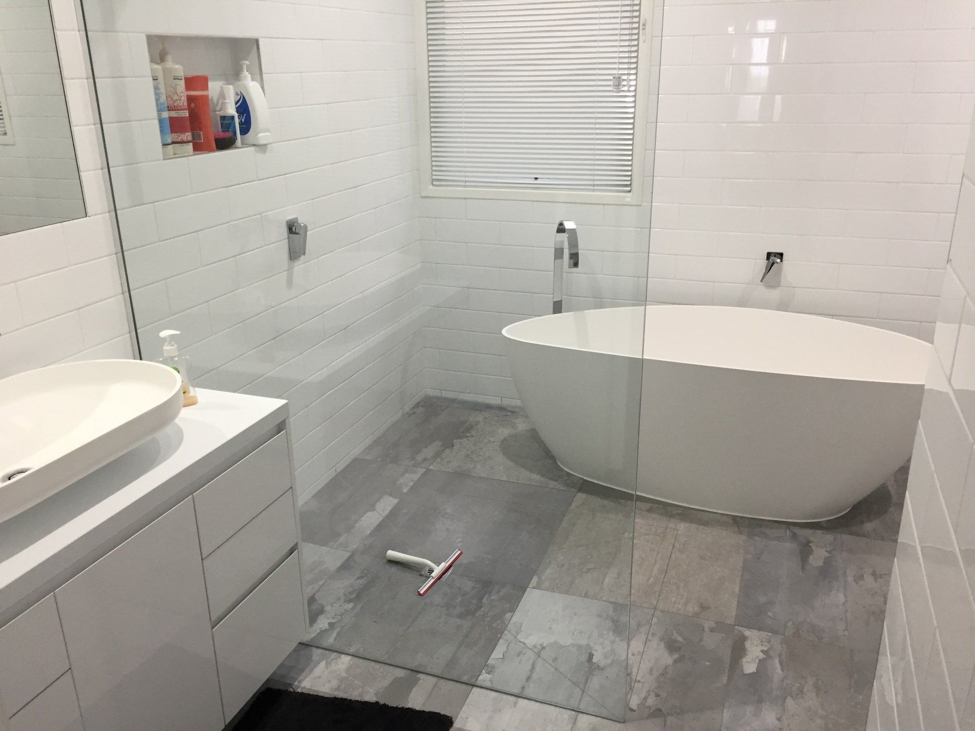 A bathroom with a bathtub , sink , and shower.