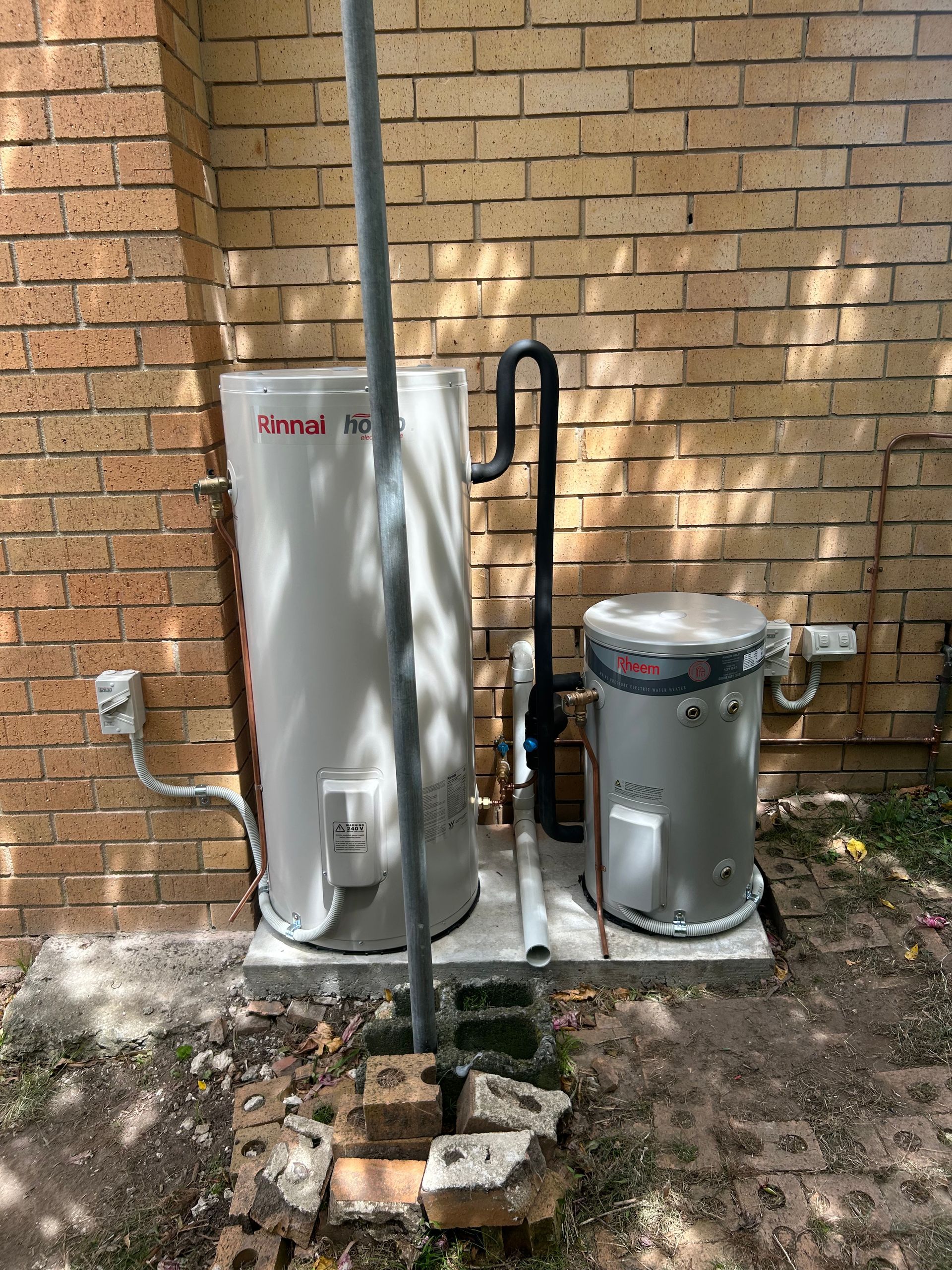 A circular Ampol AmpCharge electric vehicle wall charger mounted on a textured grey concrete wall.