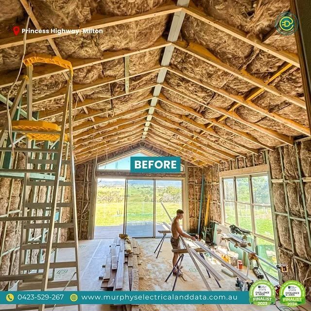 Interior view of a building under construction; insulation installed. A man works on the floor.
