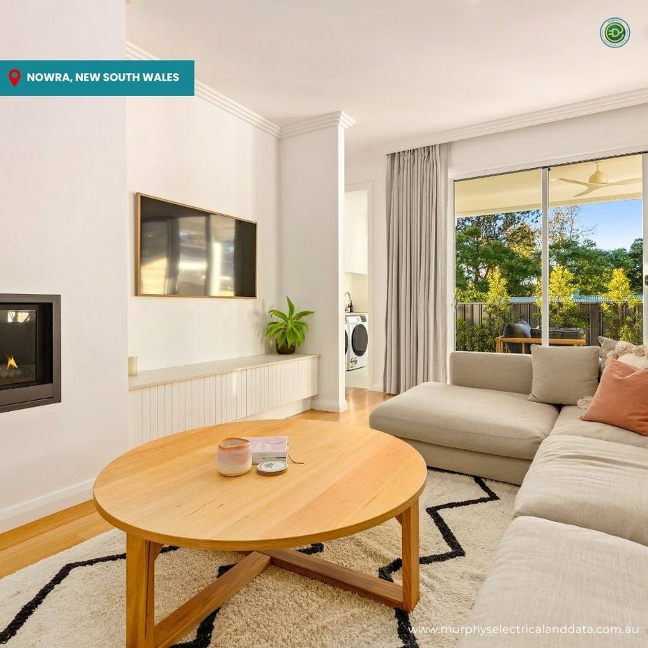 Bathroom in Nowra, New South Wales, with a round mirror, black fixtures, and textured gray walls.