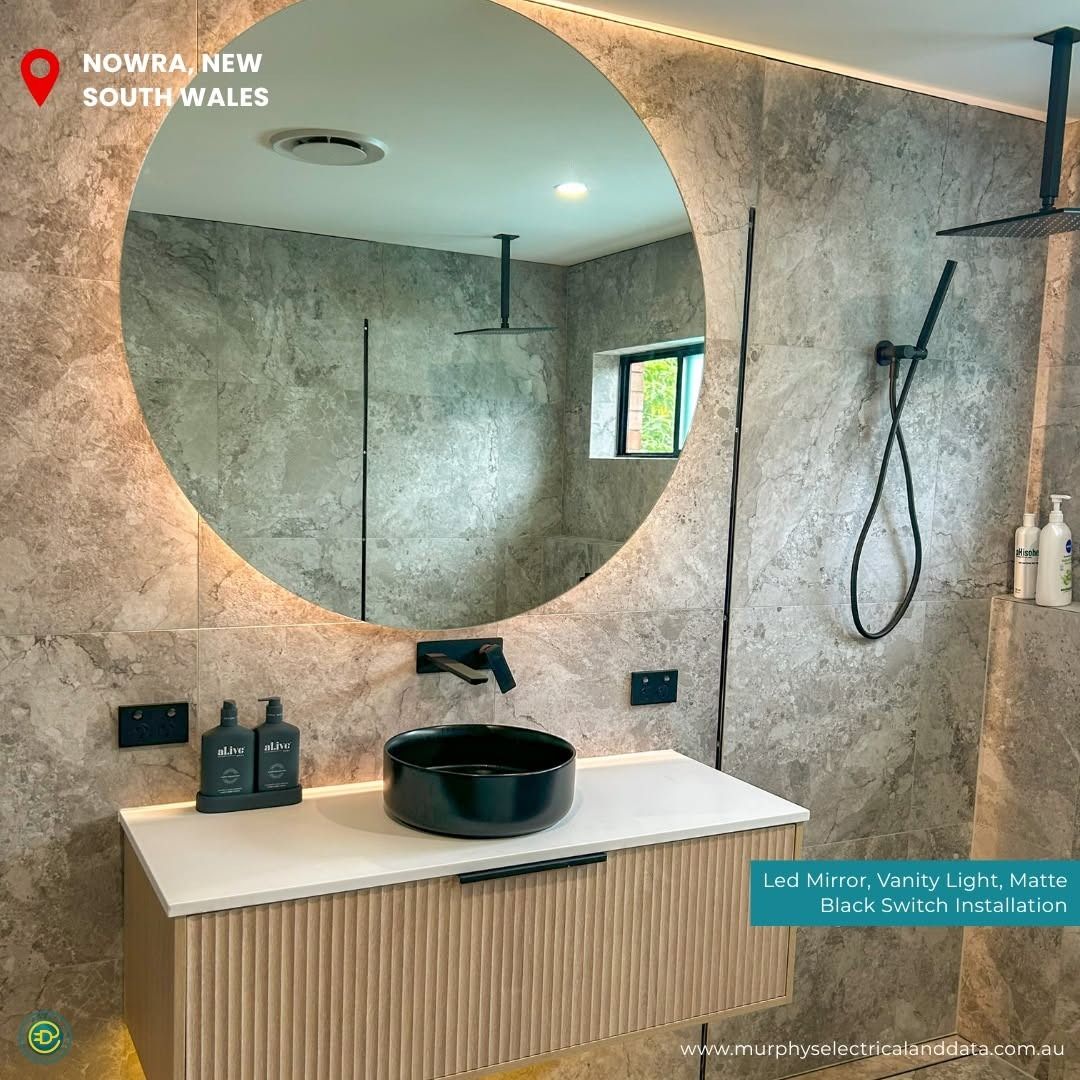 Bathroom renovation in Nowra, New South Wales featuring a floating vanity, round mirror, and gray stone tile.