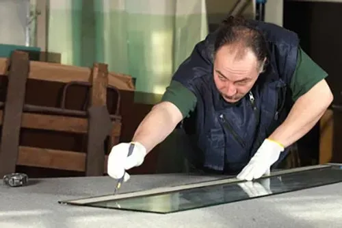 A Man is Cutting a Piece of Glass on a Table — Mesa, AZ — Arcadia Glass Company