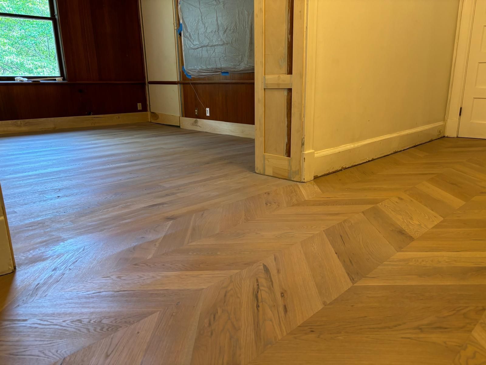 A room with a wooden floor and a herringbone pattern.