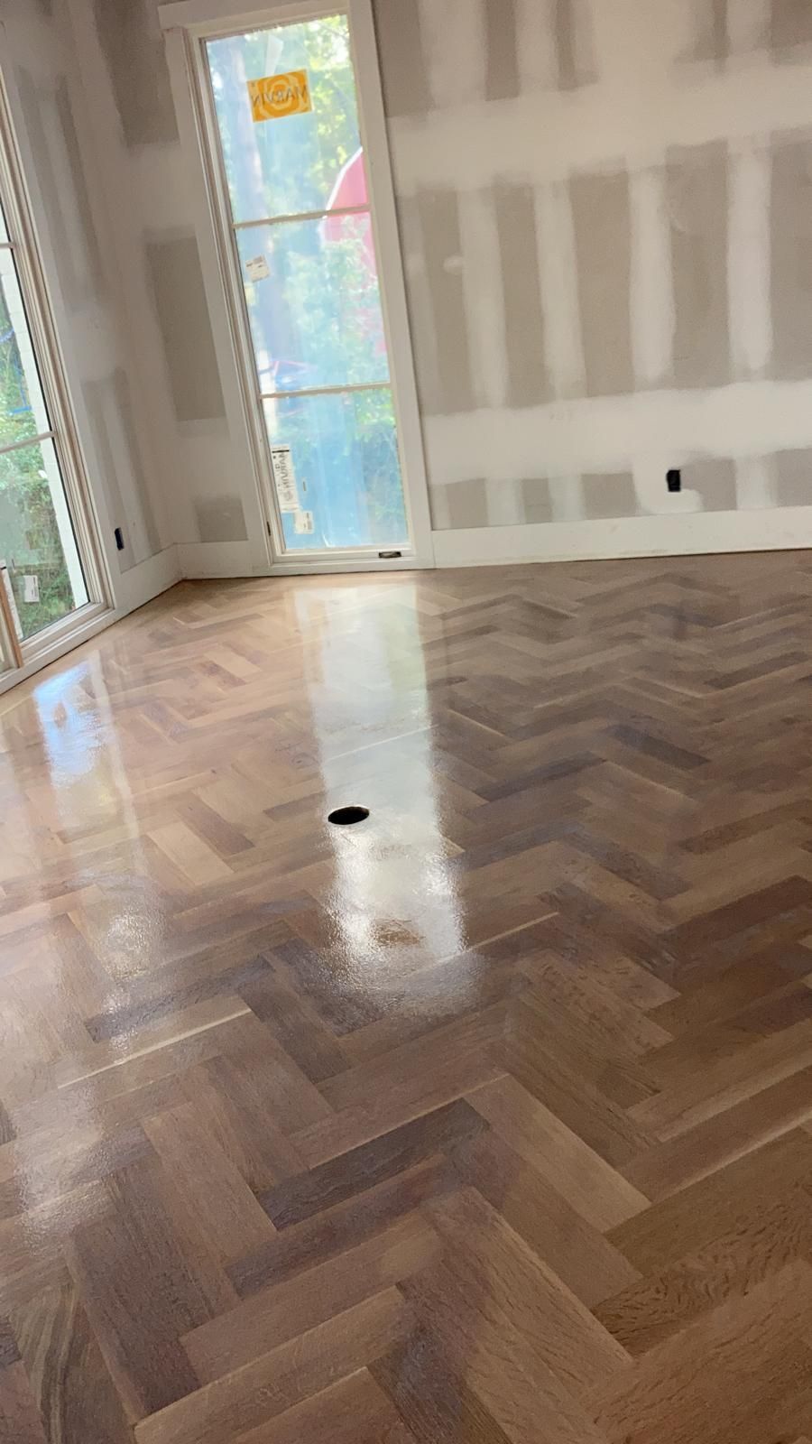A room with a wooden floor and a window.