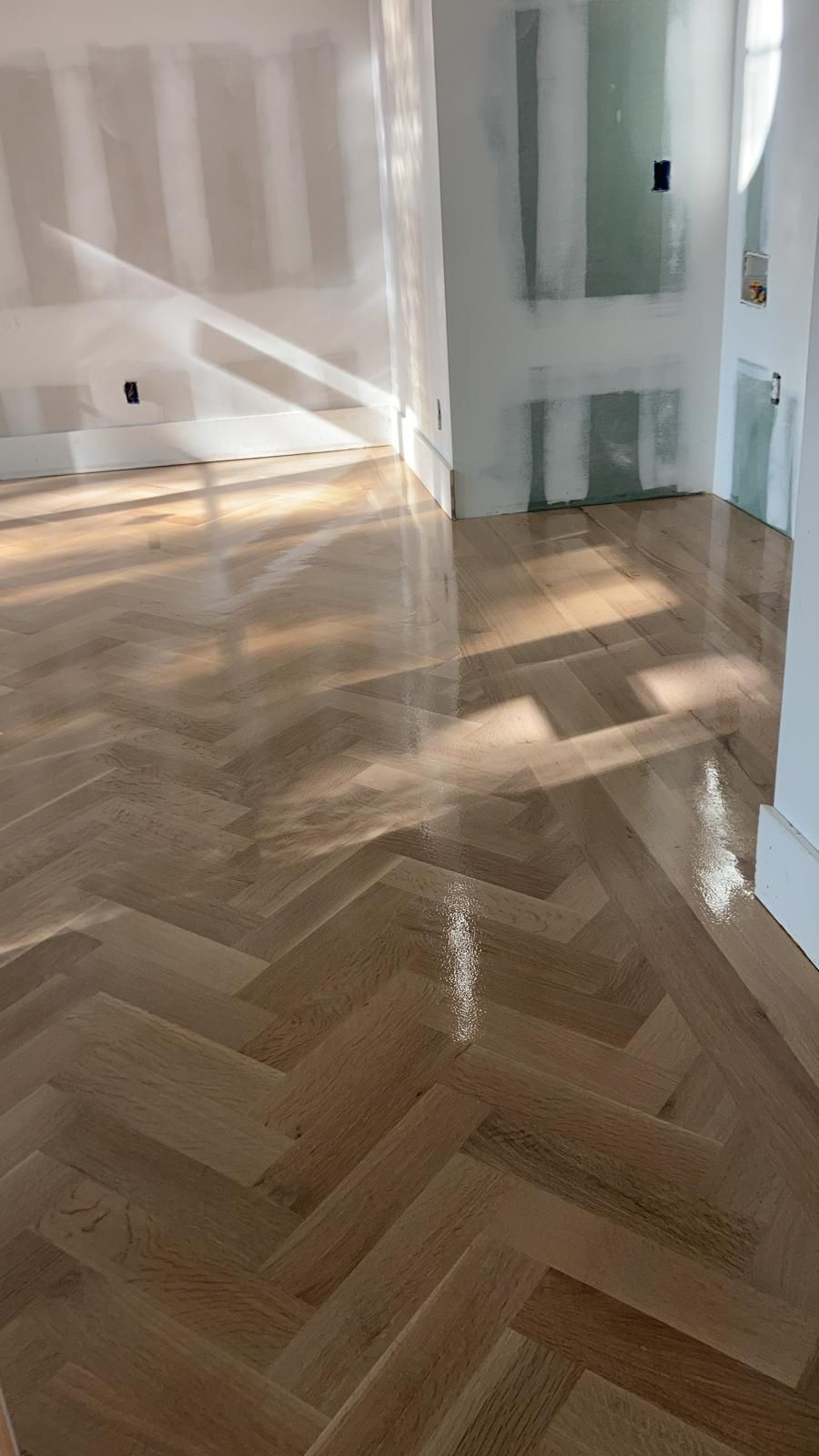 A wooden floor in a room with a herringbone pattern.