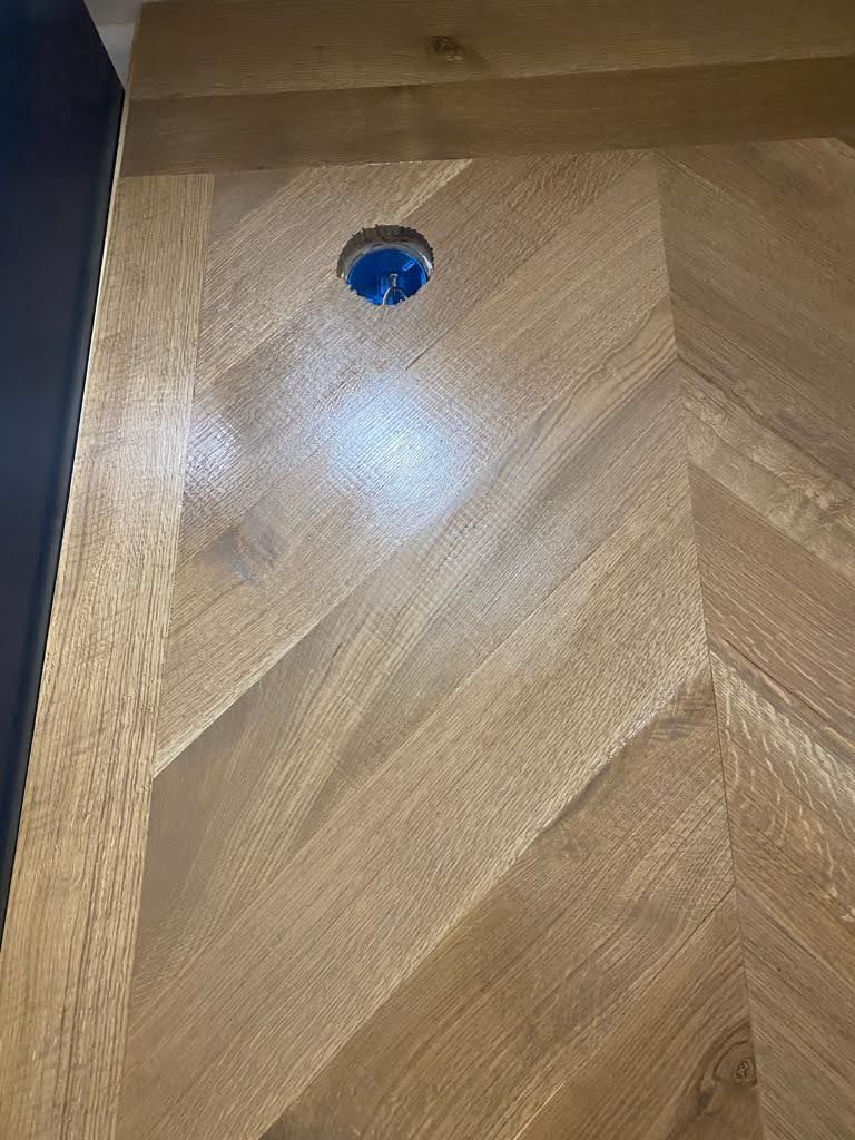 A close up of a wooden floor with a hole in it.