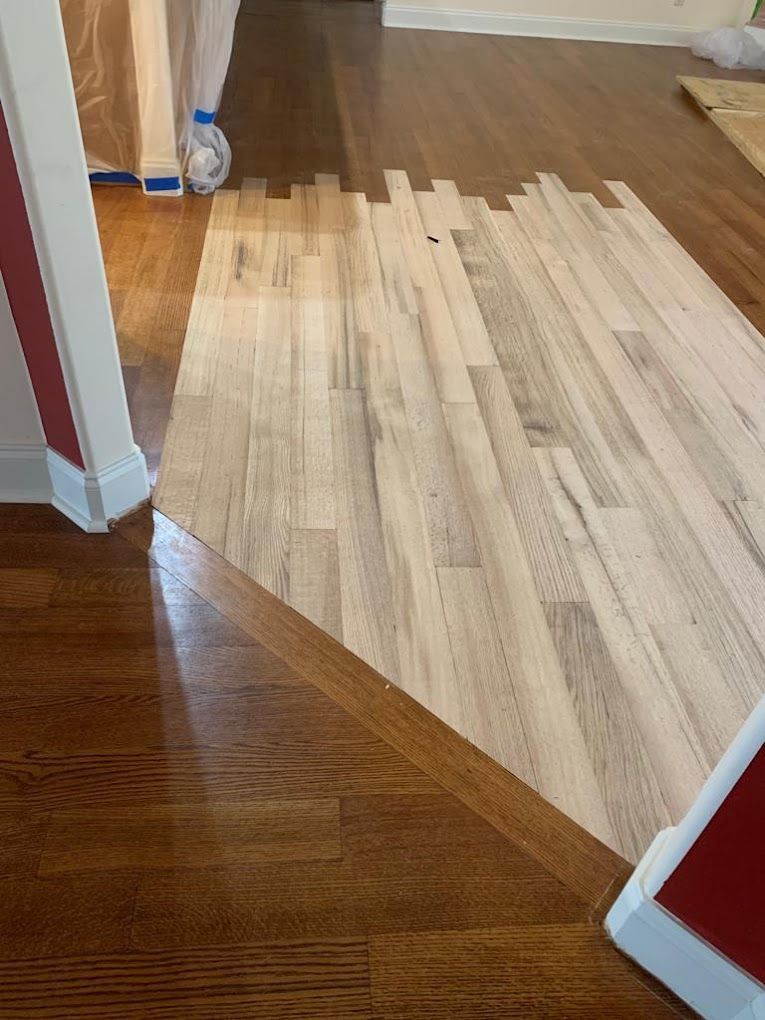 A wooden floor is being installed in a living room.