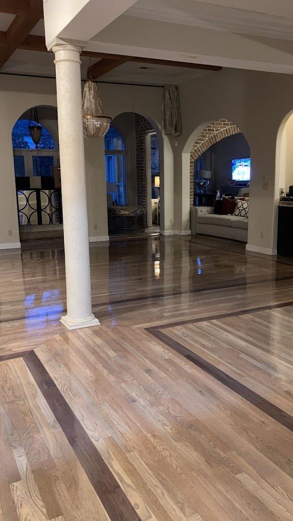 A large room with a wooden floor and columns.