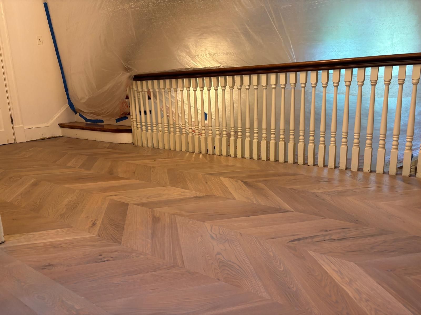A staircase with a wooden floor and white railing