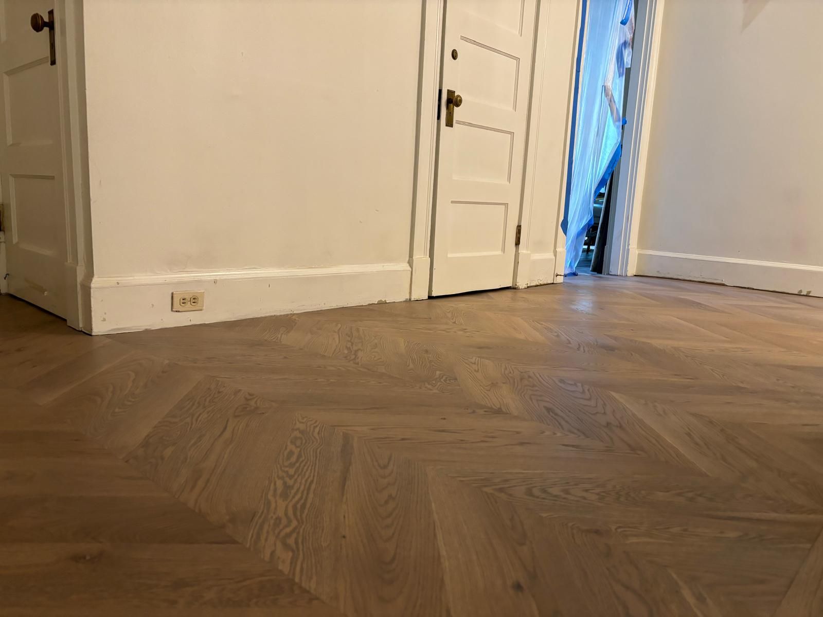 A room with a wooden floor and white walls.