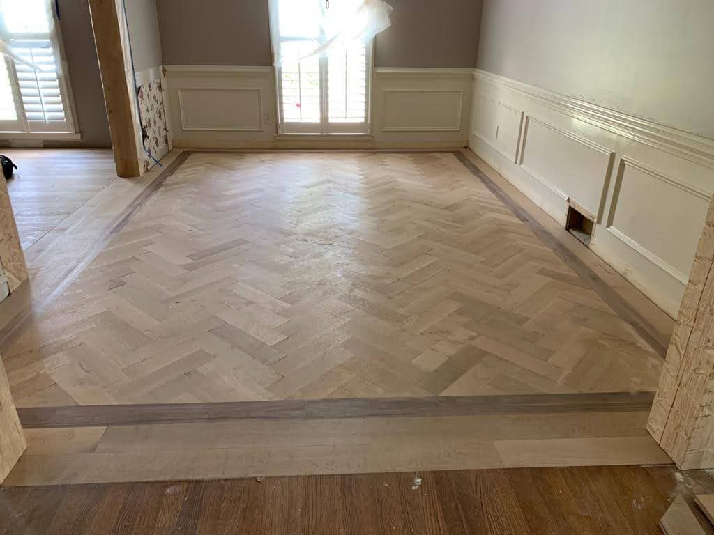 A room with a wooden floor and a herringbone pattern.