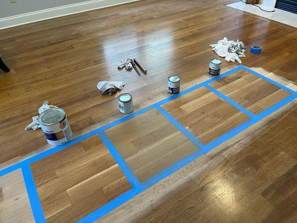A wooden floor is being painted with blue tape.