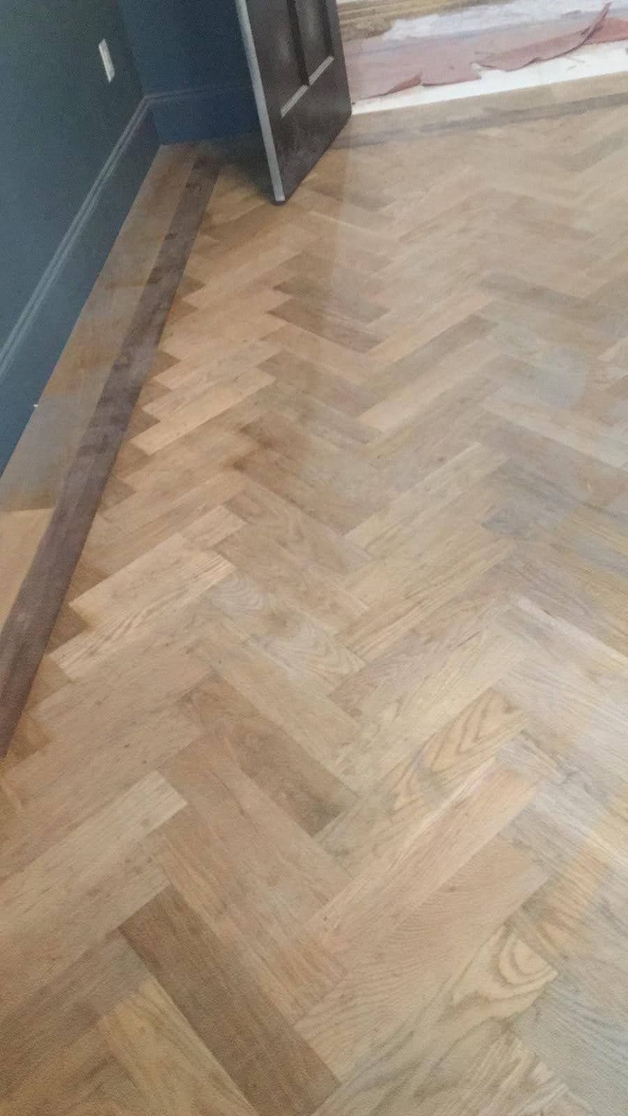 A close up of a herringbone wooden floor in a room.