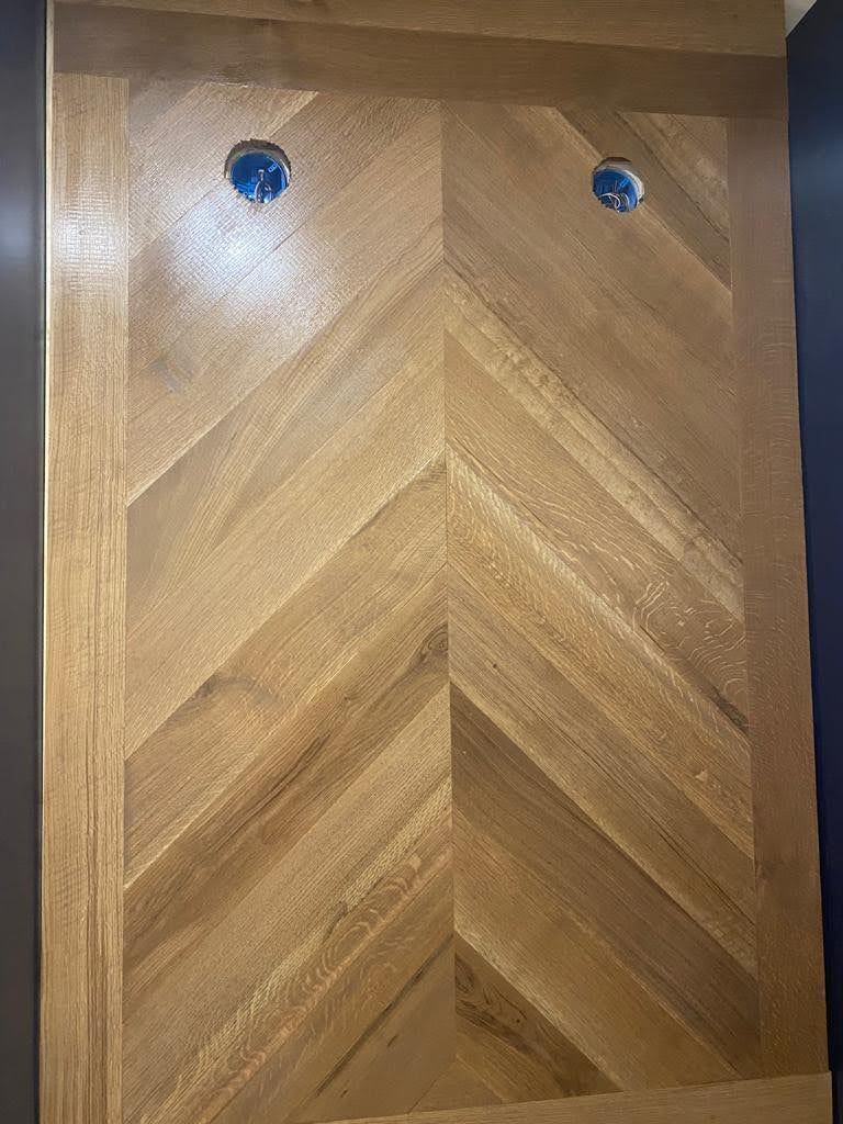 A close up of a wooden wall with a chevron pattern.