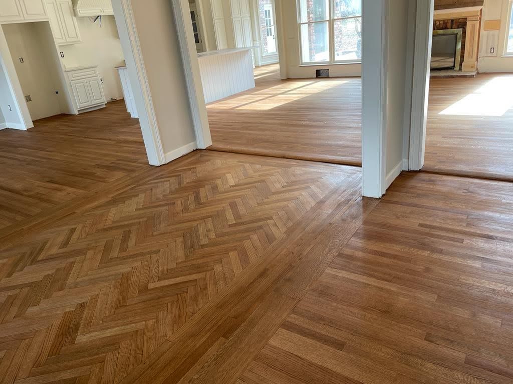 A wooden floor in a room with a herringbone pattern.