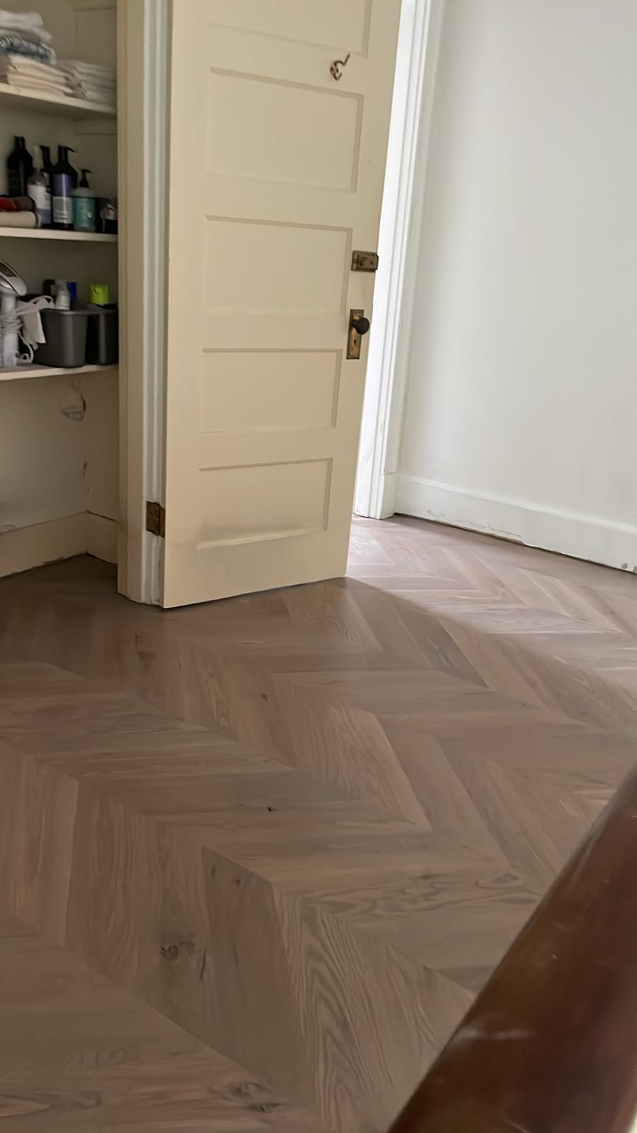 A room with a wooden floor and a white door.