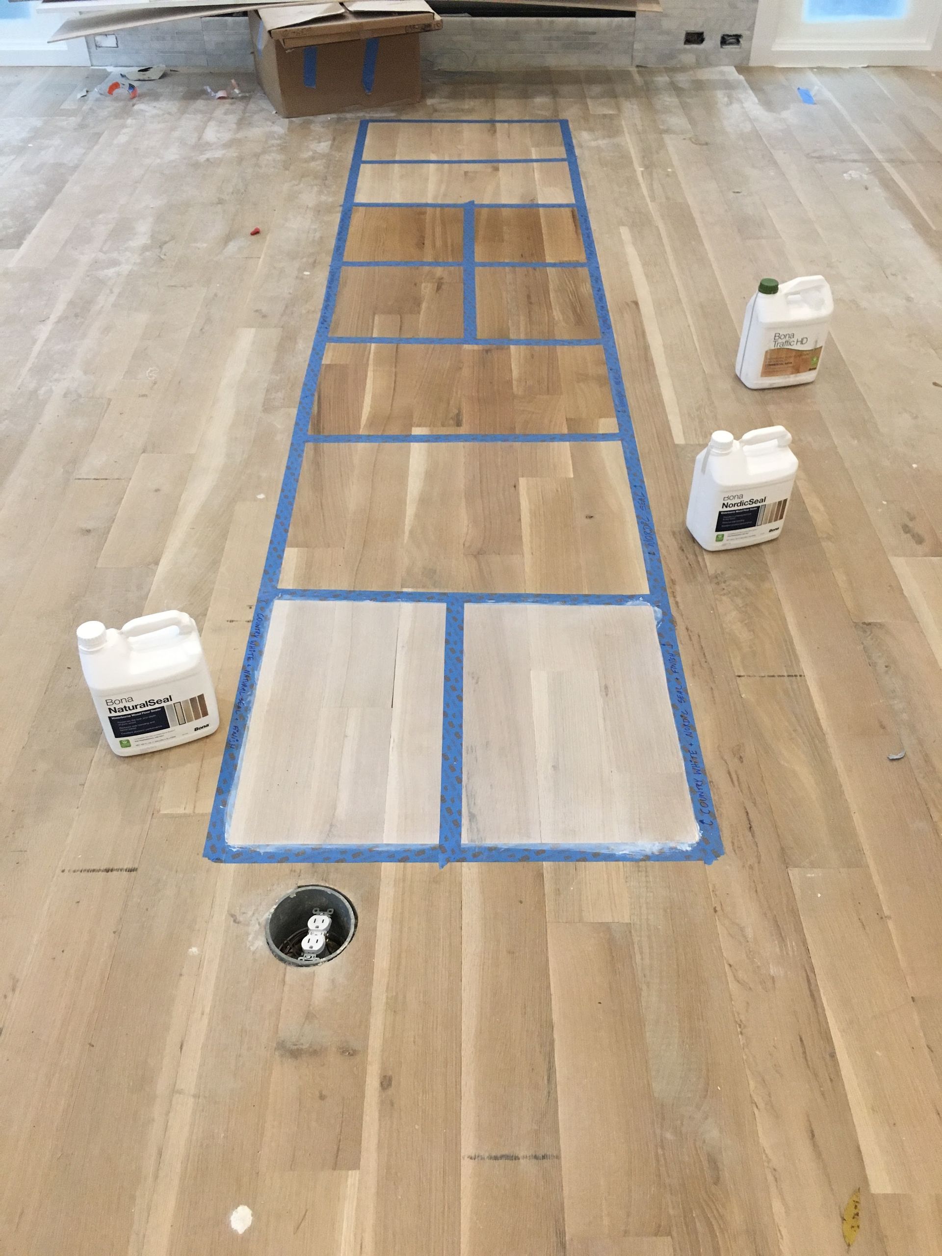 A wooden floor with bottles of paint on it.