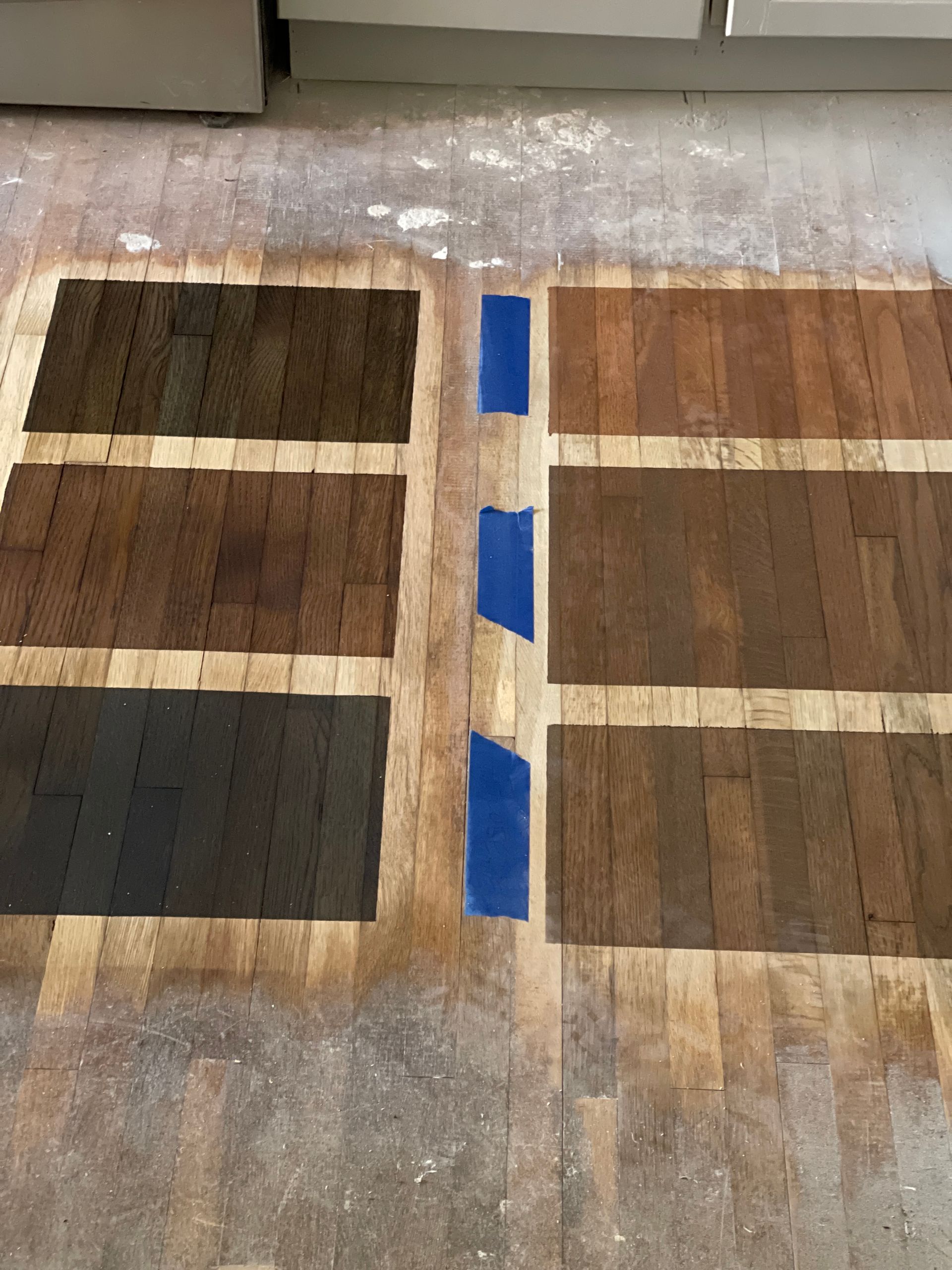 A wooden floor with different shades of paint on it