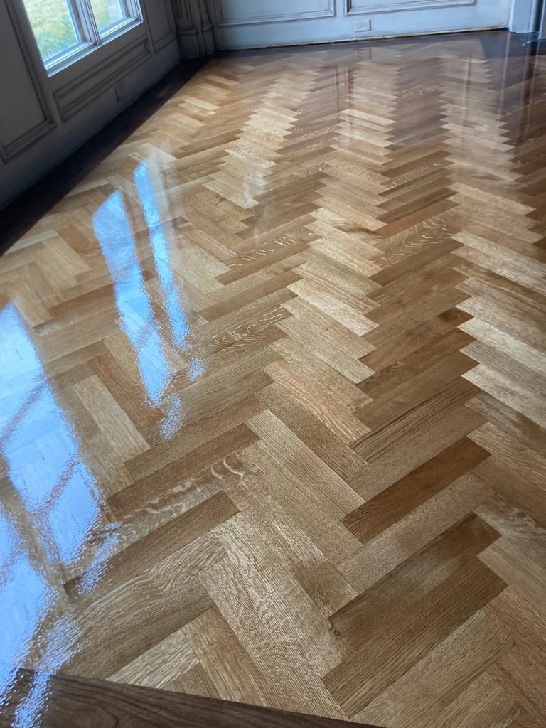 A close up of a wooden floor with a herringbone pattern.
