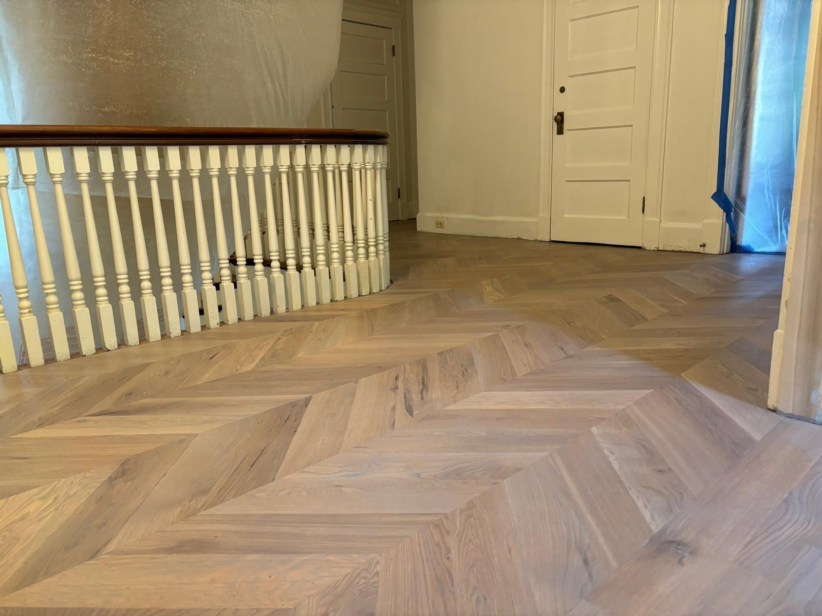 A staircase with a wooden floor and a white railing.