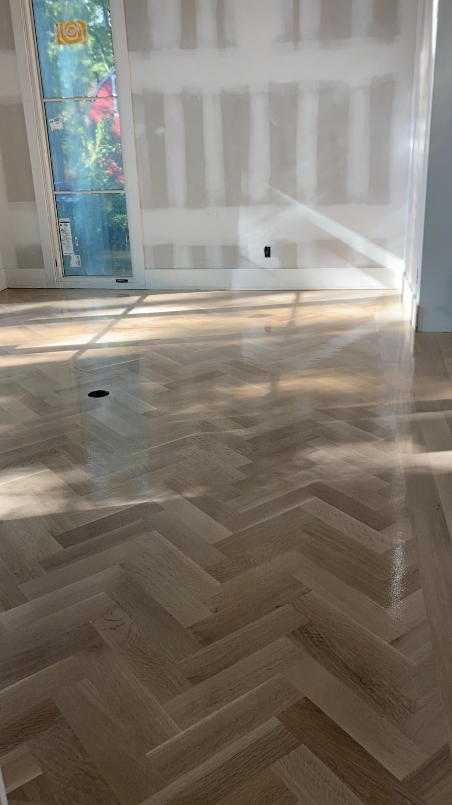 A room with a wooden floor and a sliding glass door.