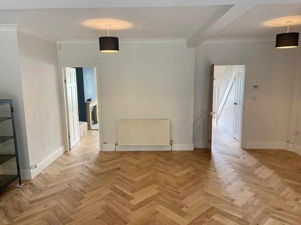 A living room with a wooden floor and white walls.