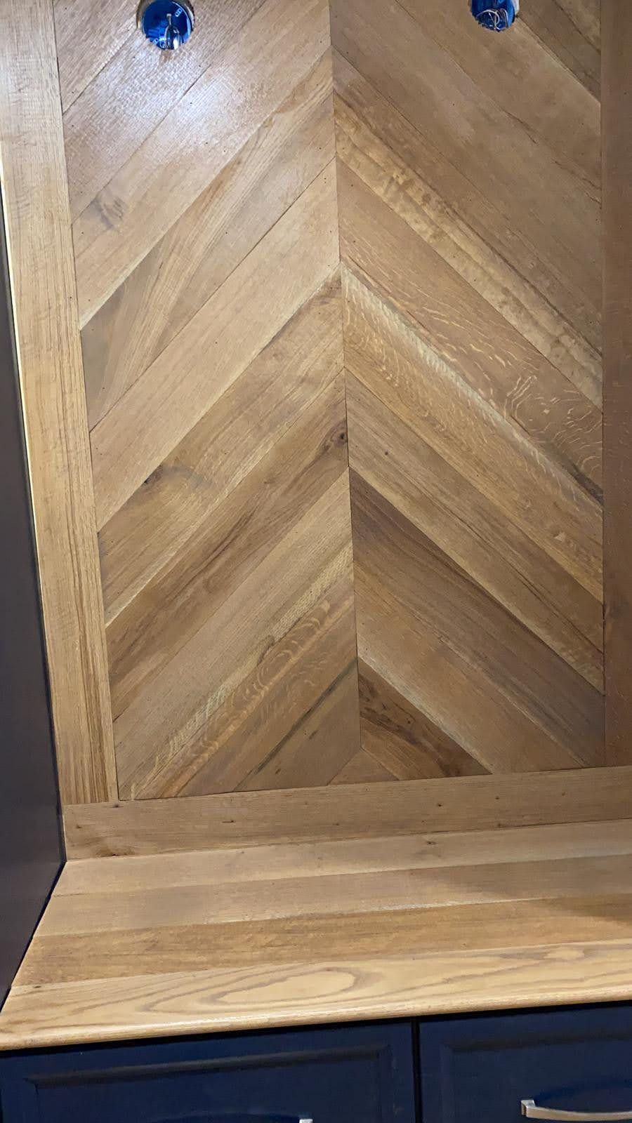 A close up of a wooden wall with a chevron pattern.