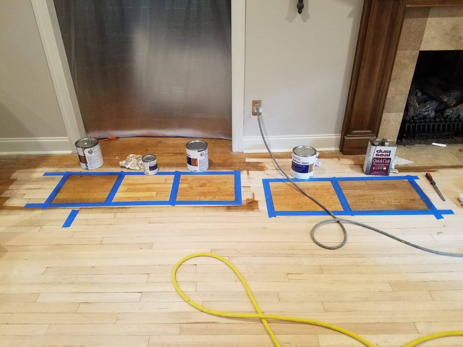 A wooden floor is being painted in a living room.