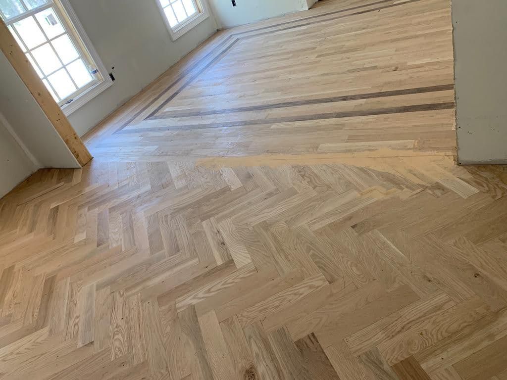 A wooden floor with a herringbone pattern in a room.