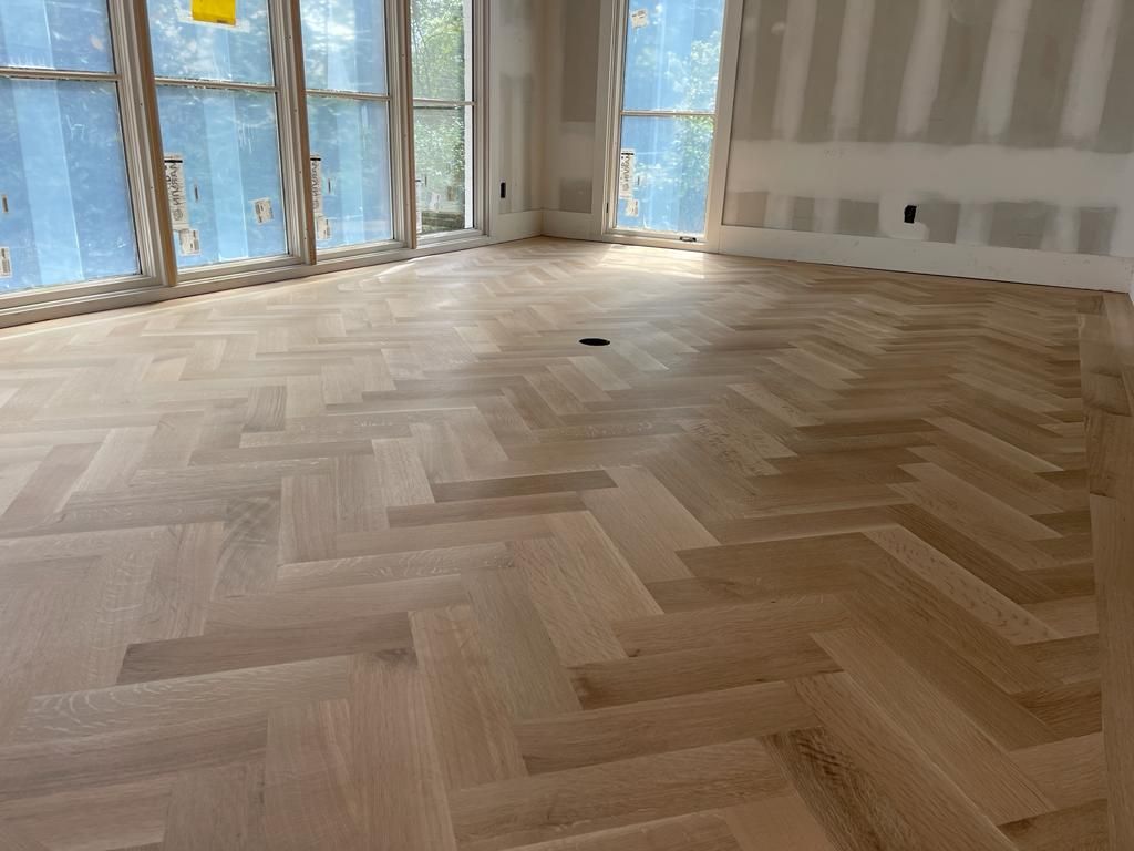 A wooden floor in a room with a herringbone pattern.