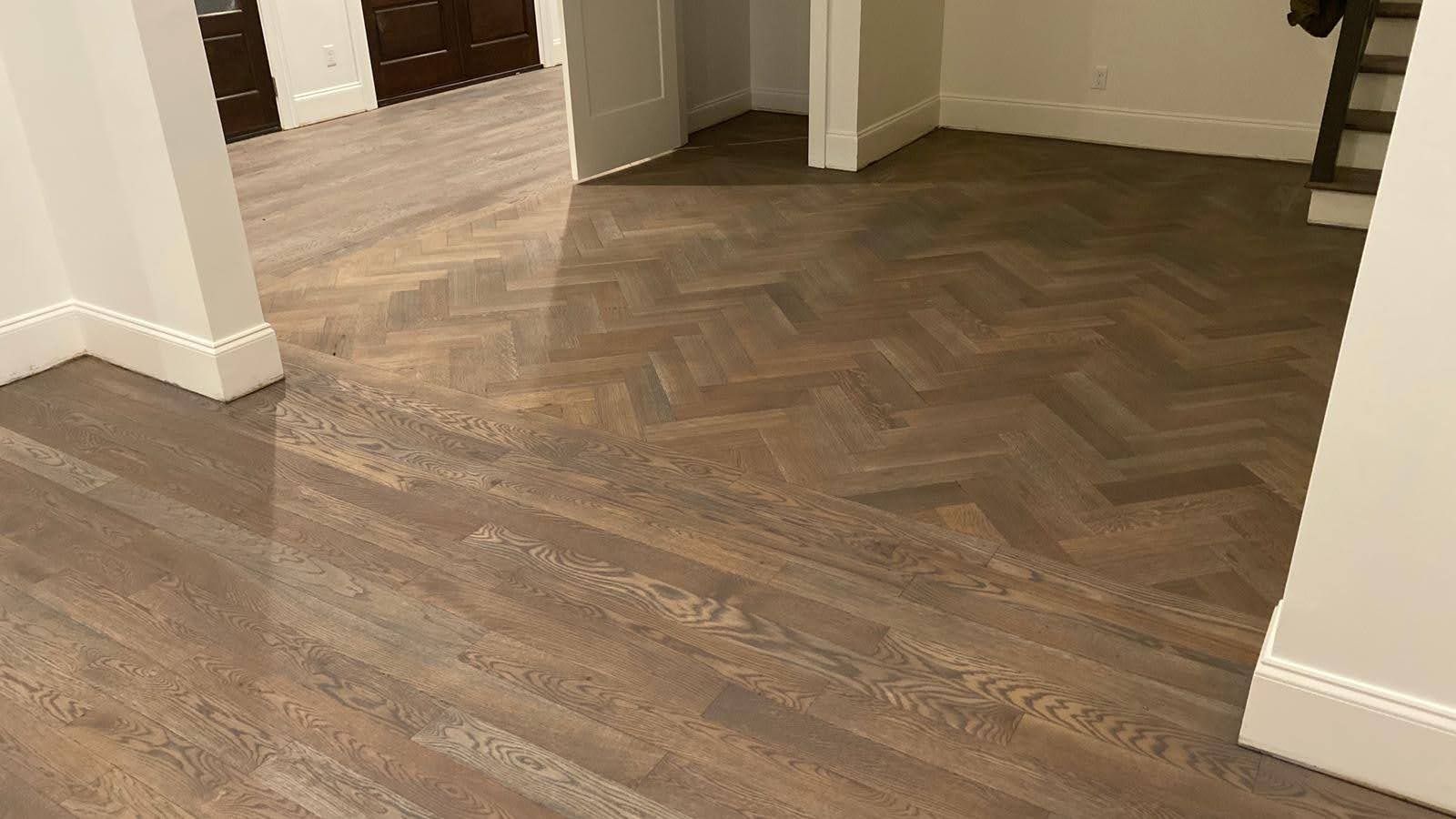 A room with a wooden floor and a herringbone pattern.