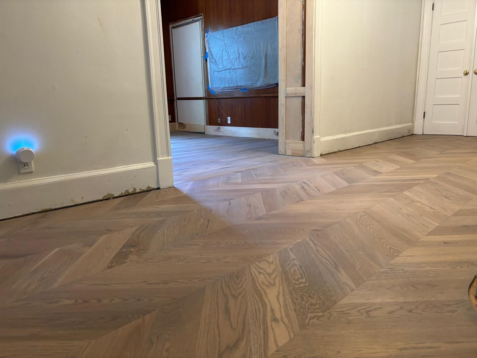 A room with a wooden floor and a herringbone pattern.