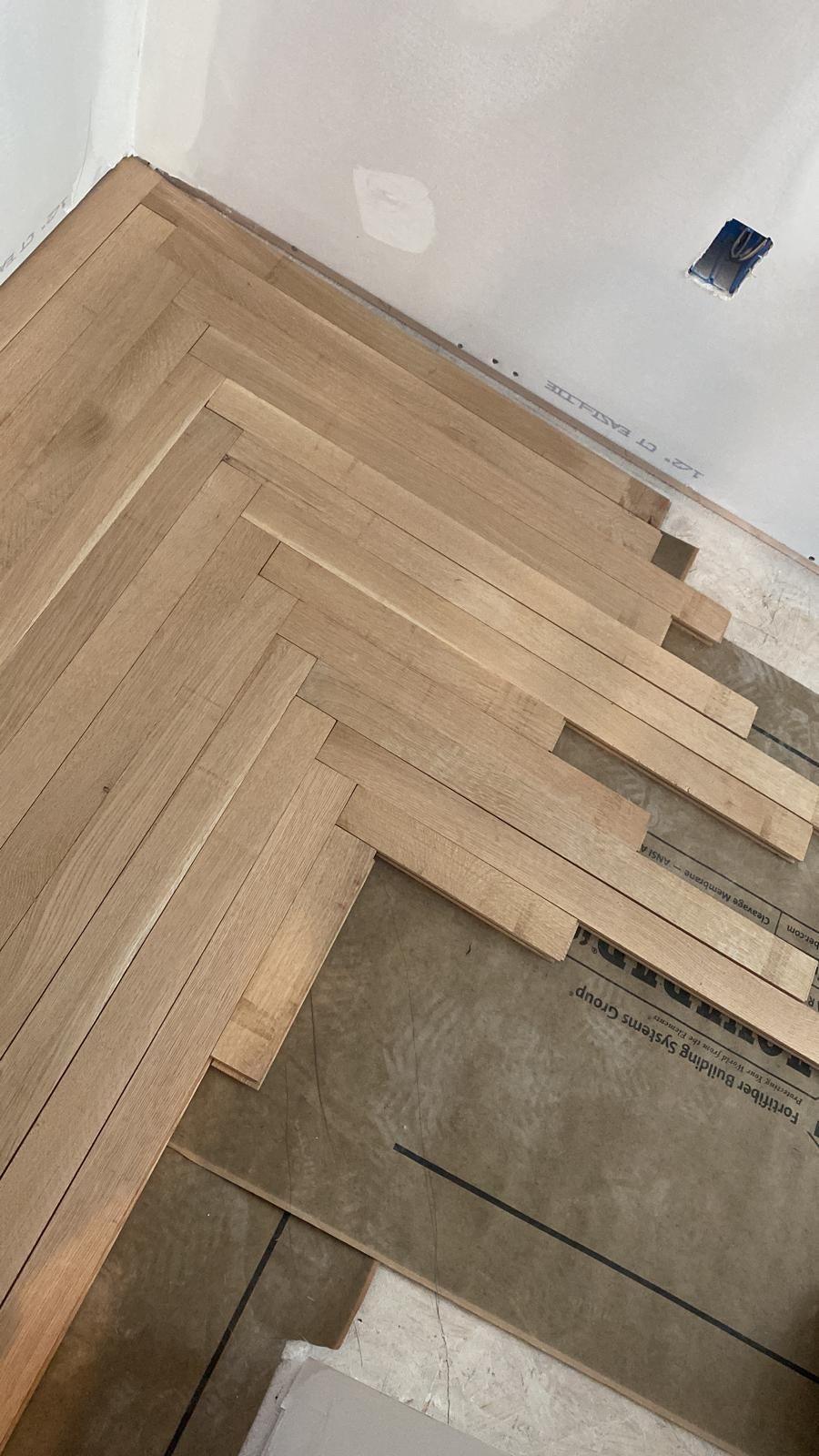 A wooden floor is being installed in a room.