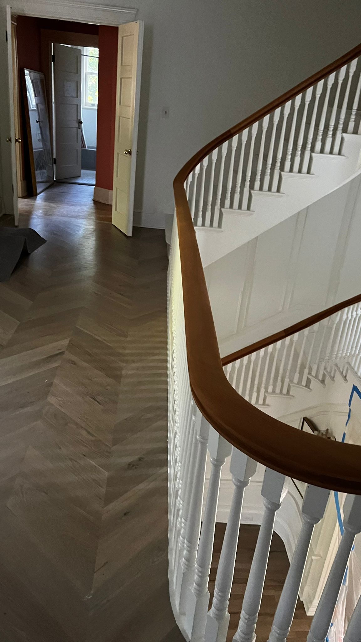 A staircase in a house with a wooden railing and a wooden floor.