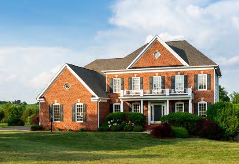 a large brick house with a large lawn in front of it