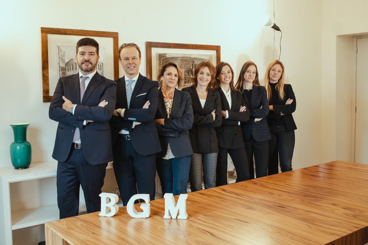 Un gruppo di persone posa per una foto davanti a un tavolo di legno.