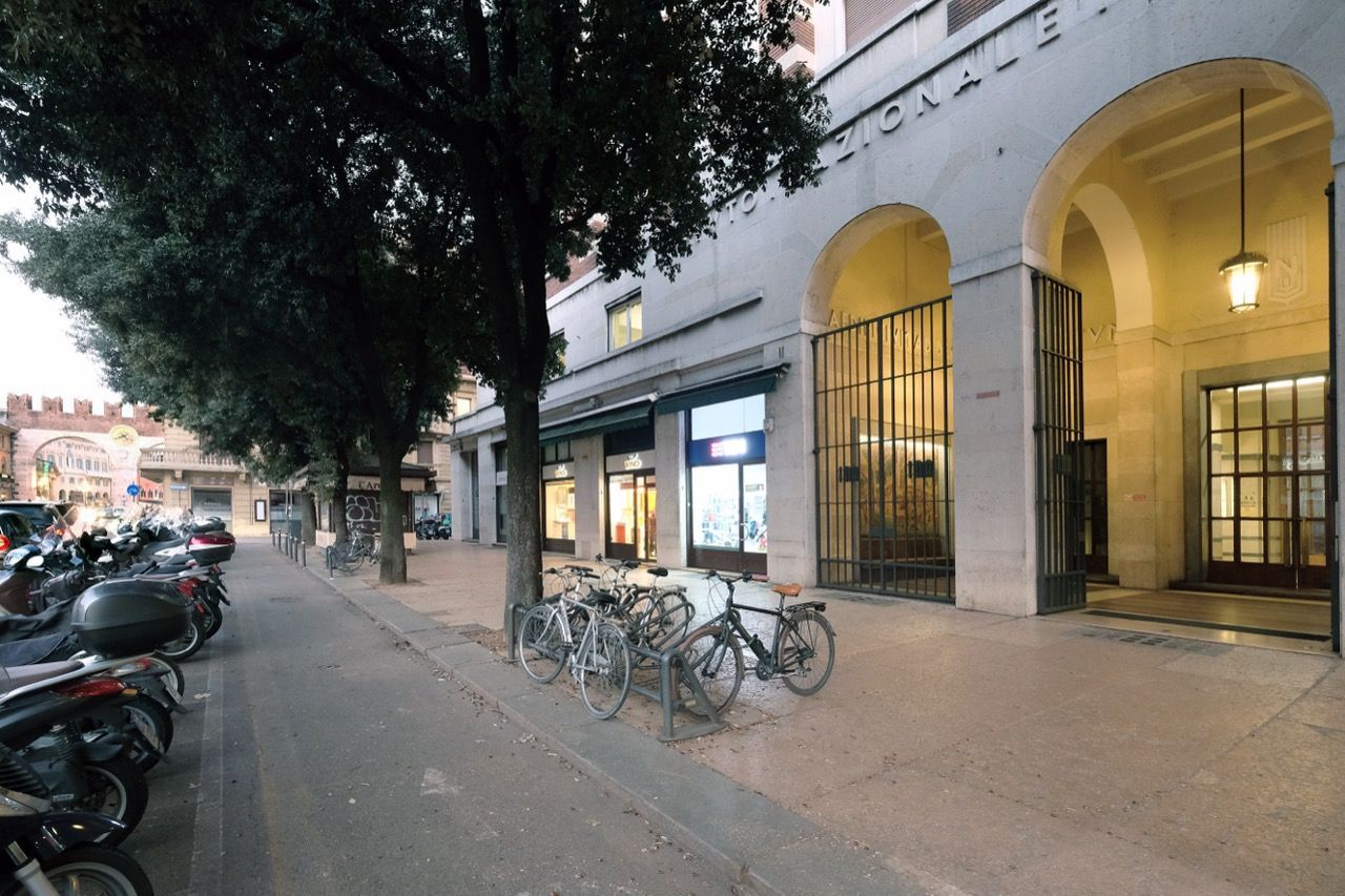 Davanti a un edificio è parcheggiata una fila di biciclette