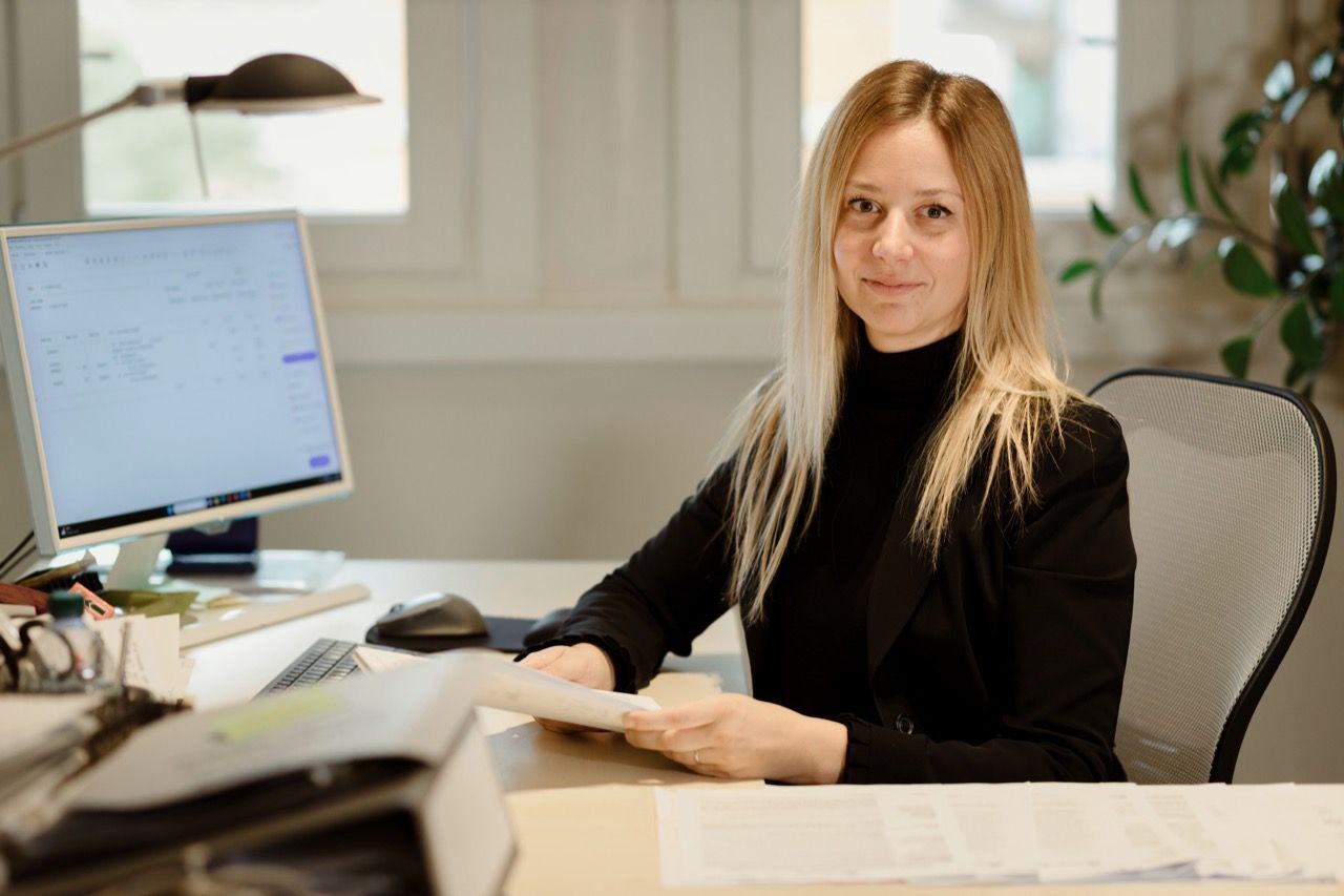 Una donna è seduta alla scrivania davanti a un computer.